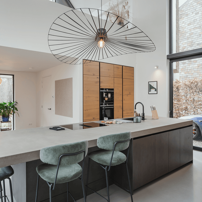 Binnenkijker: geplaatste keuken met kookeiland en betonnen aanrechtblad