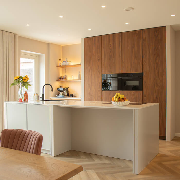 Moderne Mereno keuken met kookeiland en notenhouten kastenwand