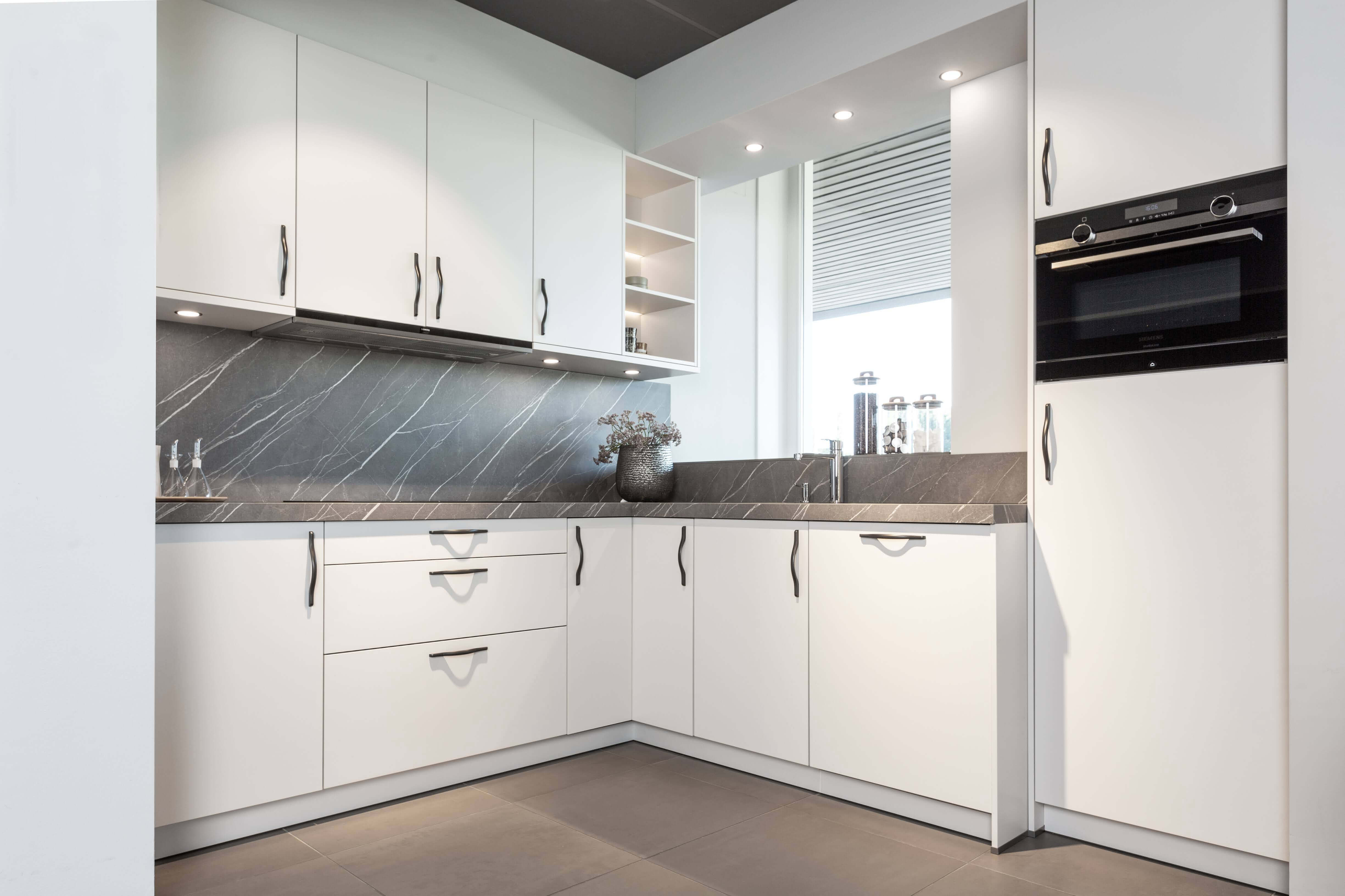 Lichte Schüller Nova keuken in schelpenwit en grijs keukenblad