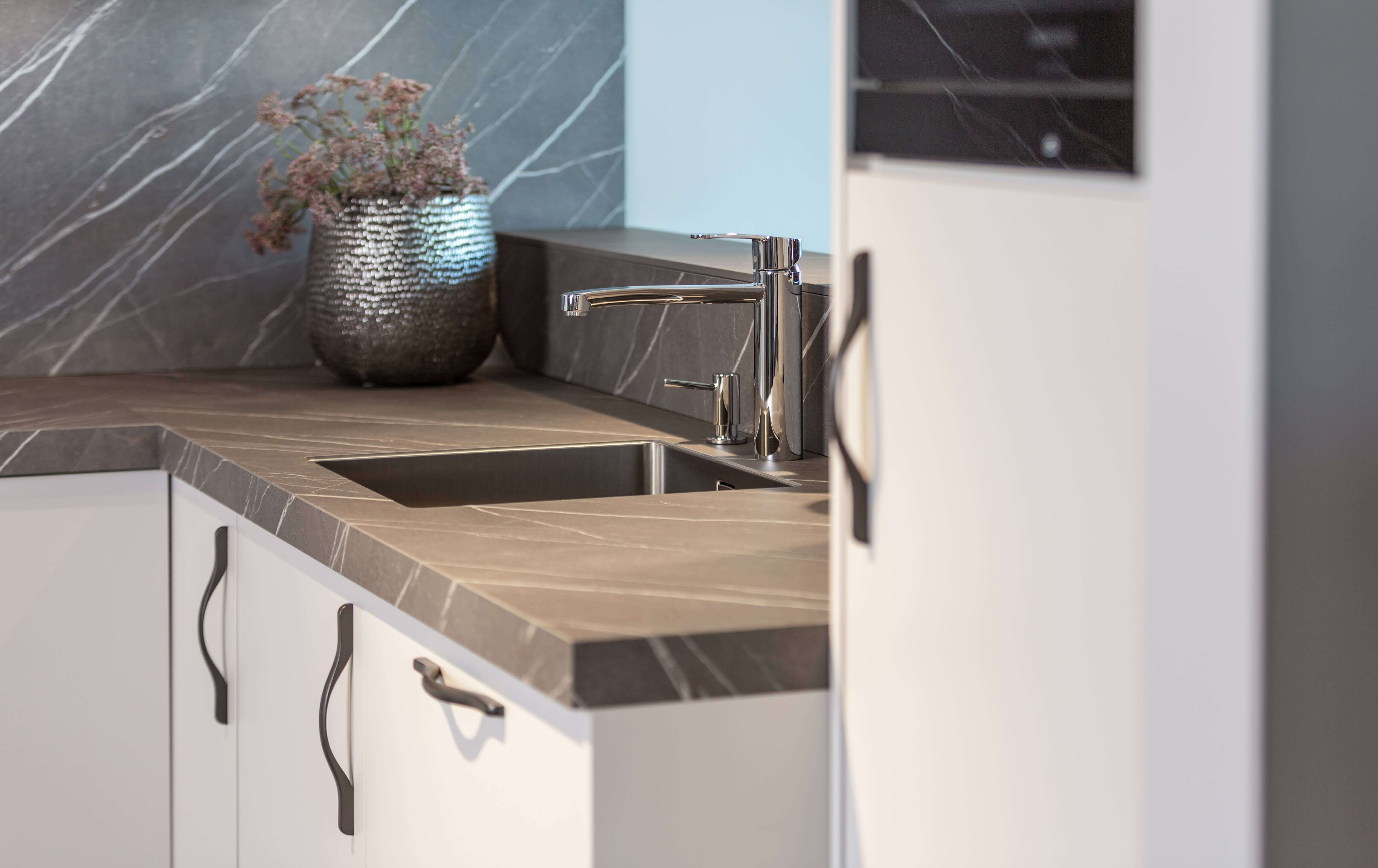 Lichte Schüller Nova keuken in schelpenwit en grijs keukenblad