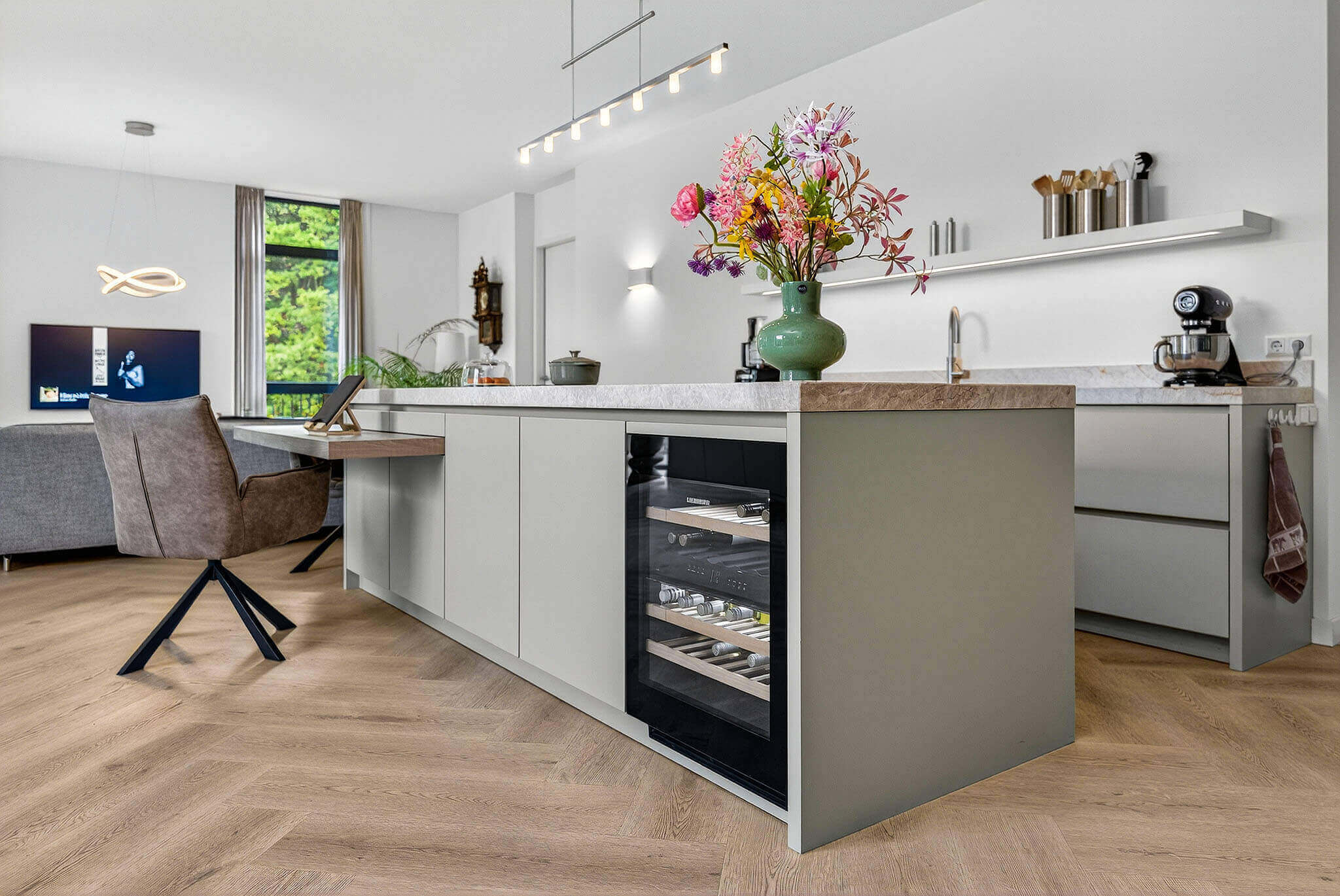 Detailopname van de Tieleman-keuken waar vakmanschap zichtbaar is in elke hoek. De combinatie van de gespoten grijze fronten en de warme houttinten van het Sherwood barblad zorgt voor een sfeervol geheel.