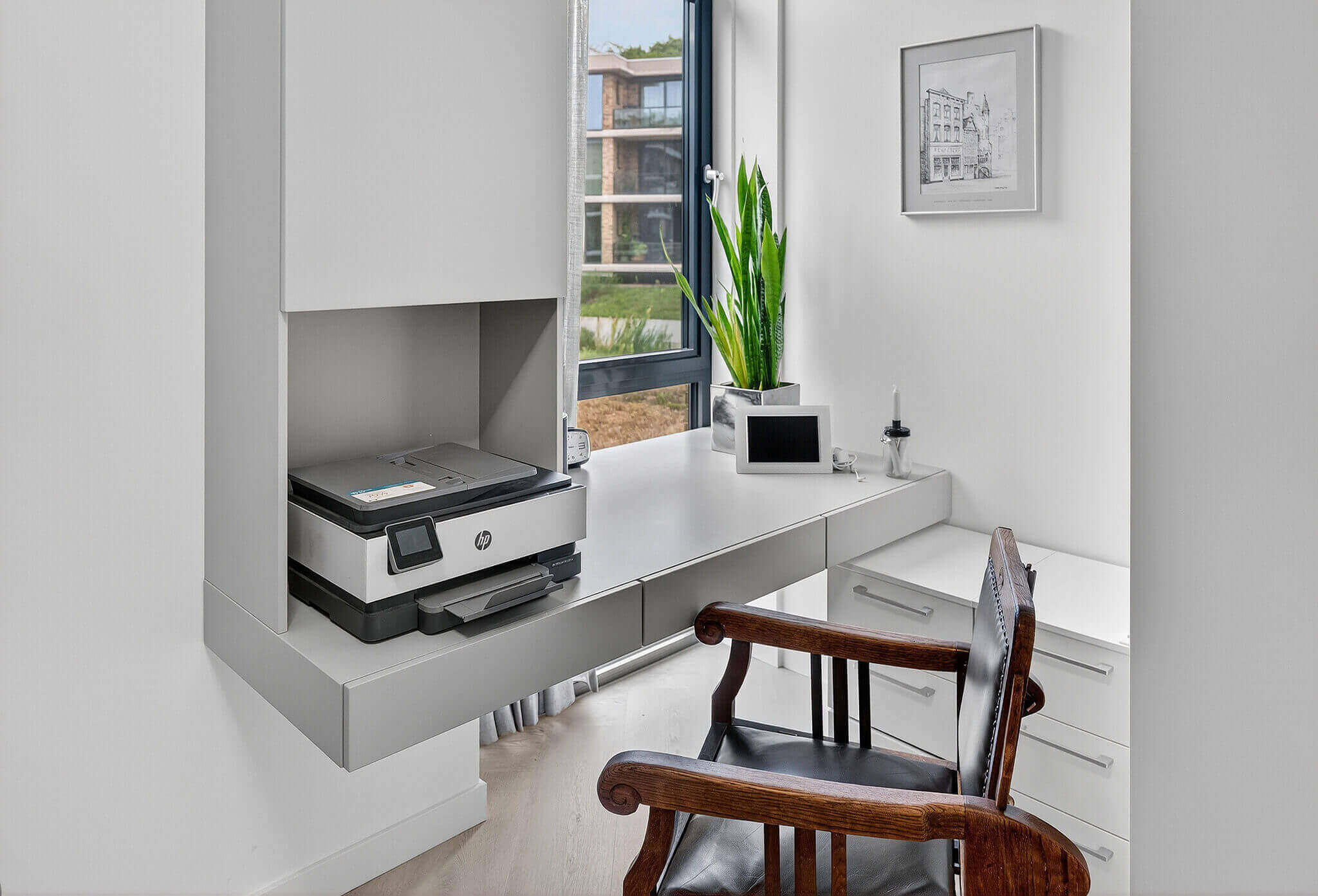 Een rustige plek om aan te werken met een bureau op maat dat precies past bij de rest van het lichtgrijze interieur.