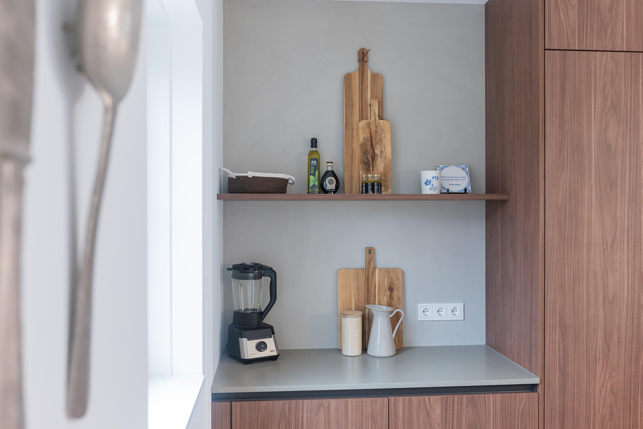 Stijlvolle koffienis in een walnoothouten kastenwand van een Tieleman-keuken voor een opgeruimd aanrechtblad.