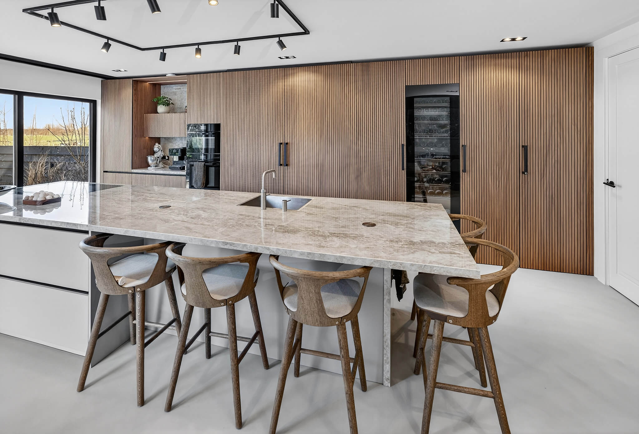 Moderne greeploze Tieleman-keuken met een groot kookeiland en spoeleiland van marmer.