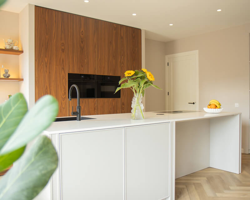 Moderne Mereno keuken met kookeiland en notenhouten kastenwand