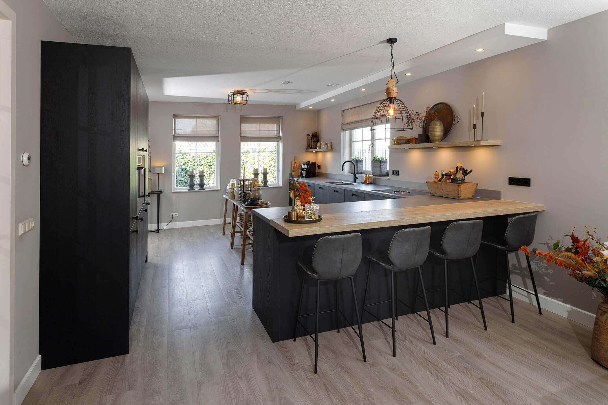 Moderne keuken met kookeiland met ge&iuml;ntegreerde eettafel.